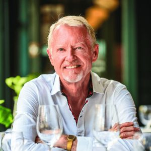 Ken Haycock sits in a restaurant, smiling at the camera