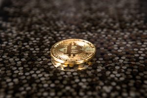 Gold bitcoin lying down in a sea of brown hexagons.
